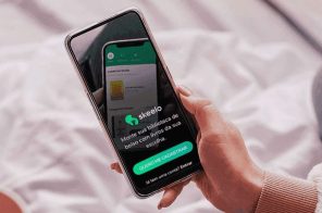 Uma mão segurando um celular. Na tela, o acesso principal ao aplicativo do Skeelo.