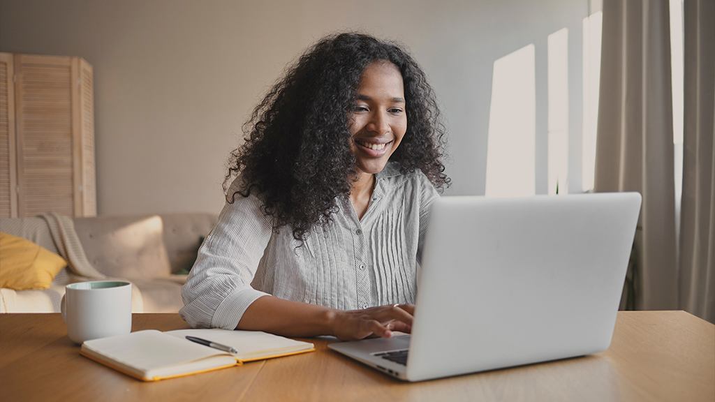 Uma mulher usando o computador e se organizando para o trabalho home office.